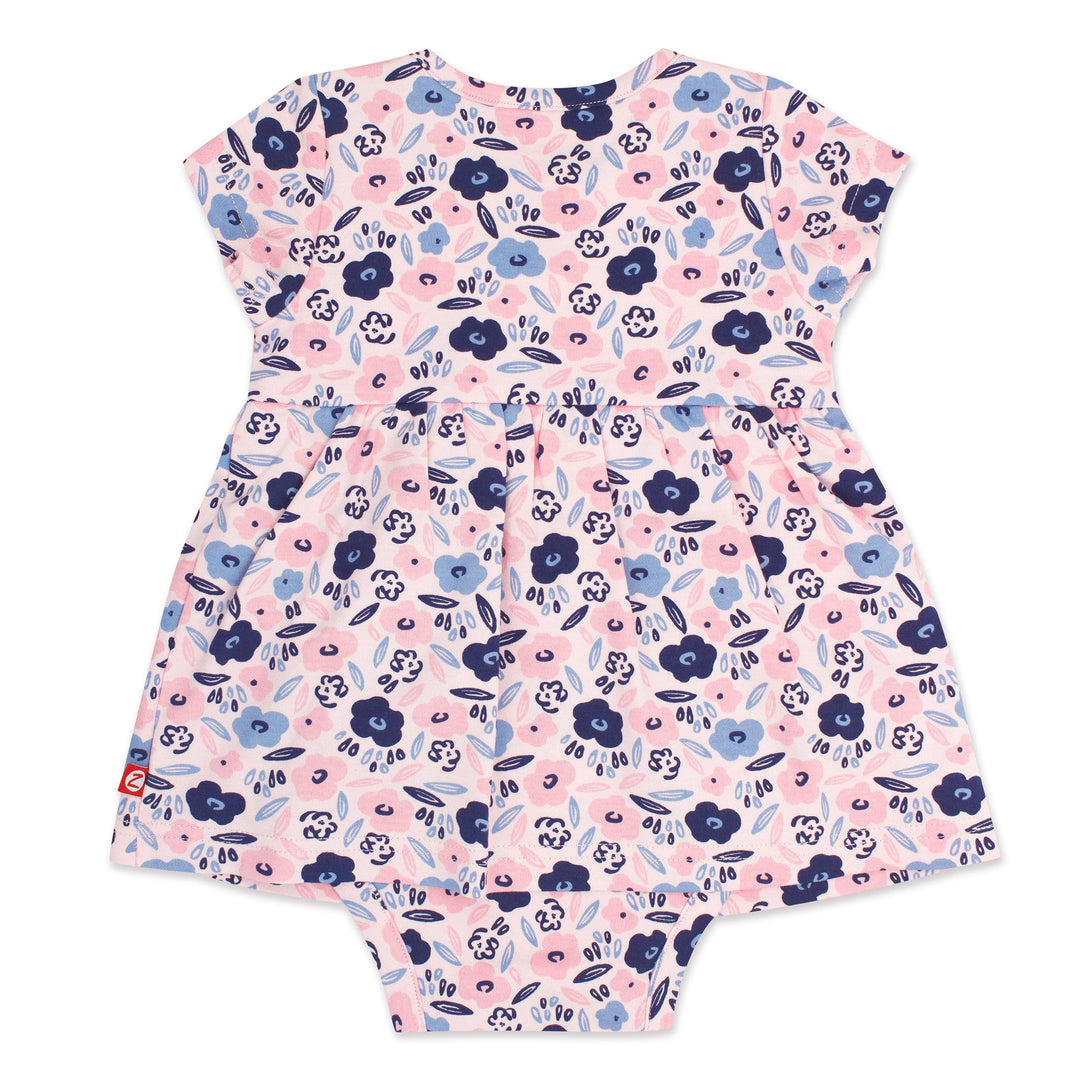 A short-sleeved romper dress for a baby girl with a blossoms print in pink, blue, and white colors.