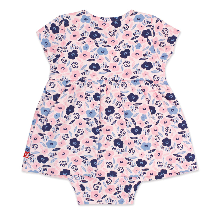 A short-sleeved romper dress for a baby girl with a blossoms print in pink, blue, and white colors.