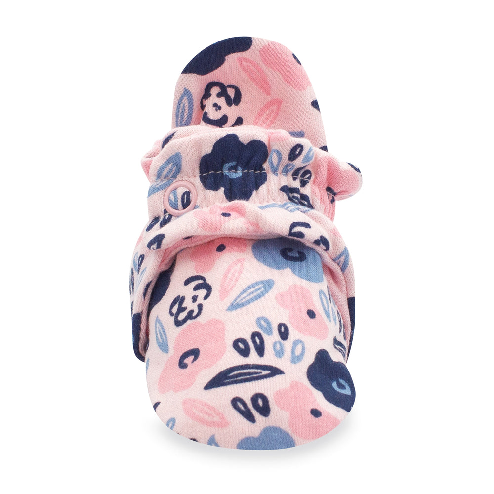 A pair of pink organic cotton baby booties with a floral and dots pattern.