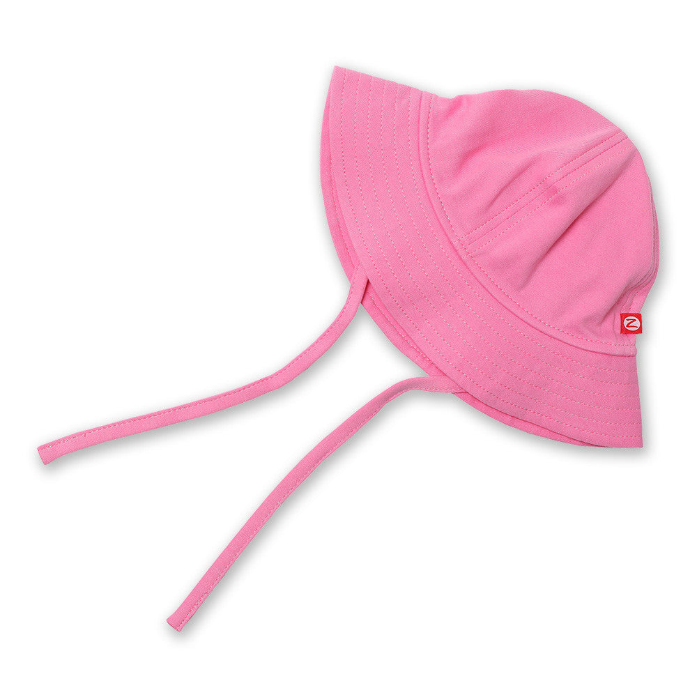 A hot pink sun hat with a wide brim and chin ties made from 100% cotton, displayed on a white background.