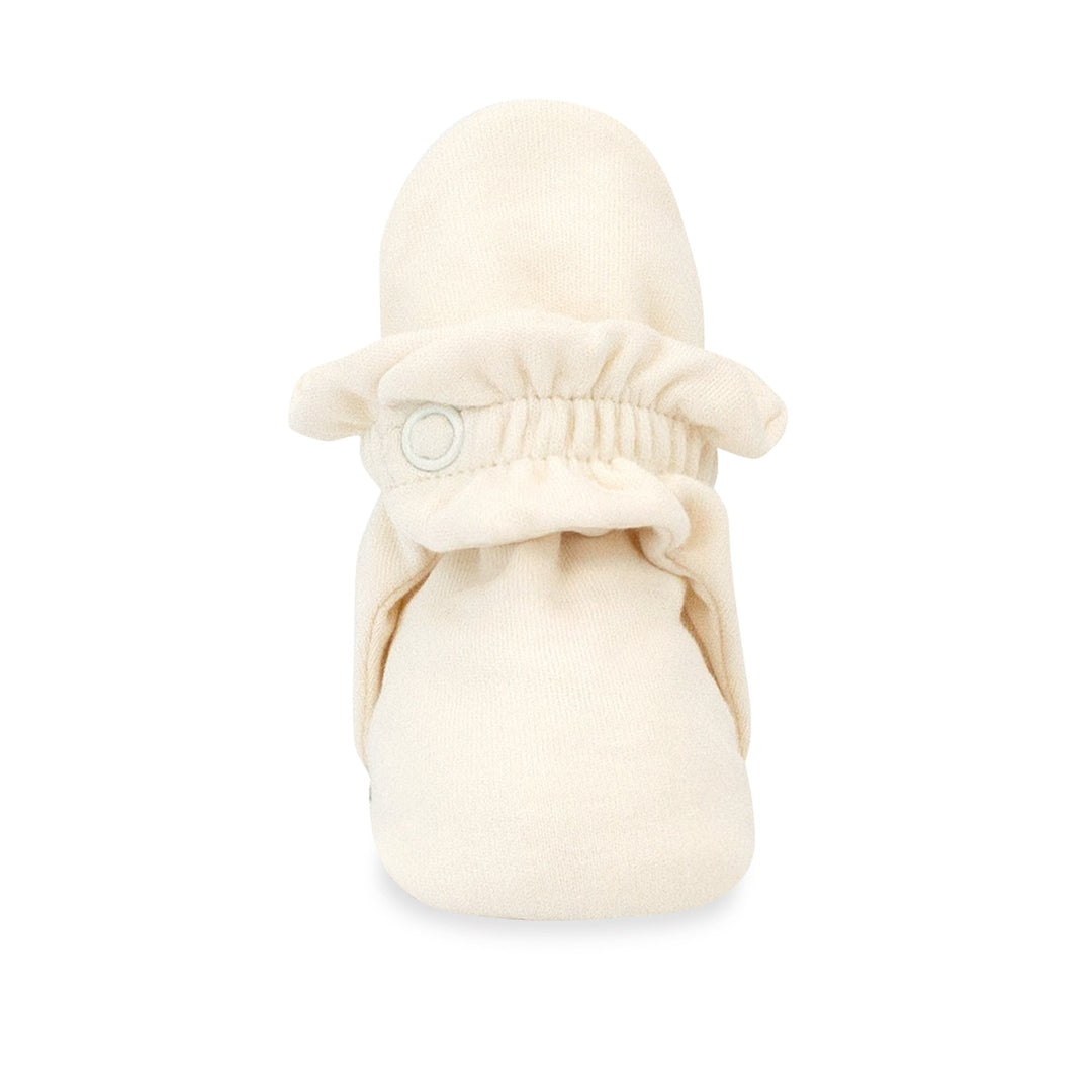 Beige organic cotton baby booties with rubber grippers on the sole.