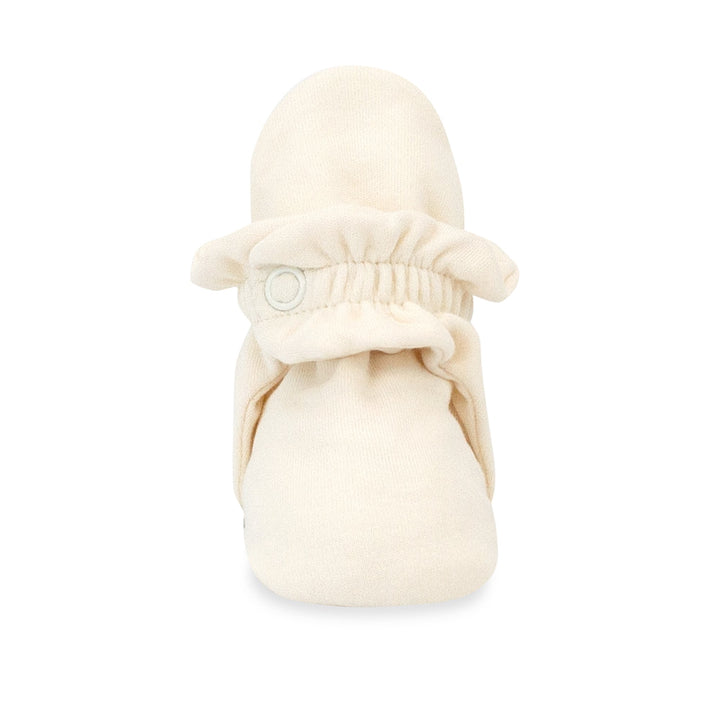 Beige organic cotton baby booties with rubber grippers on the sole.