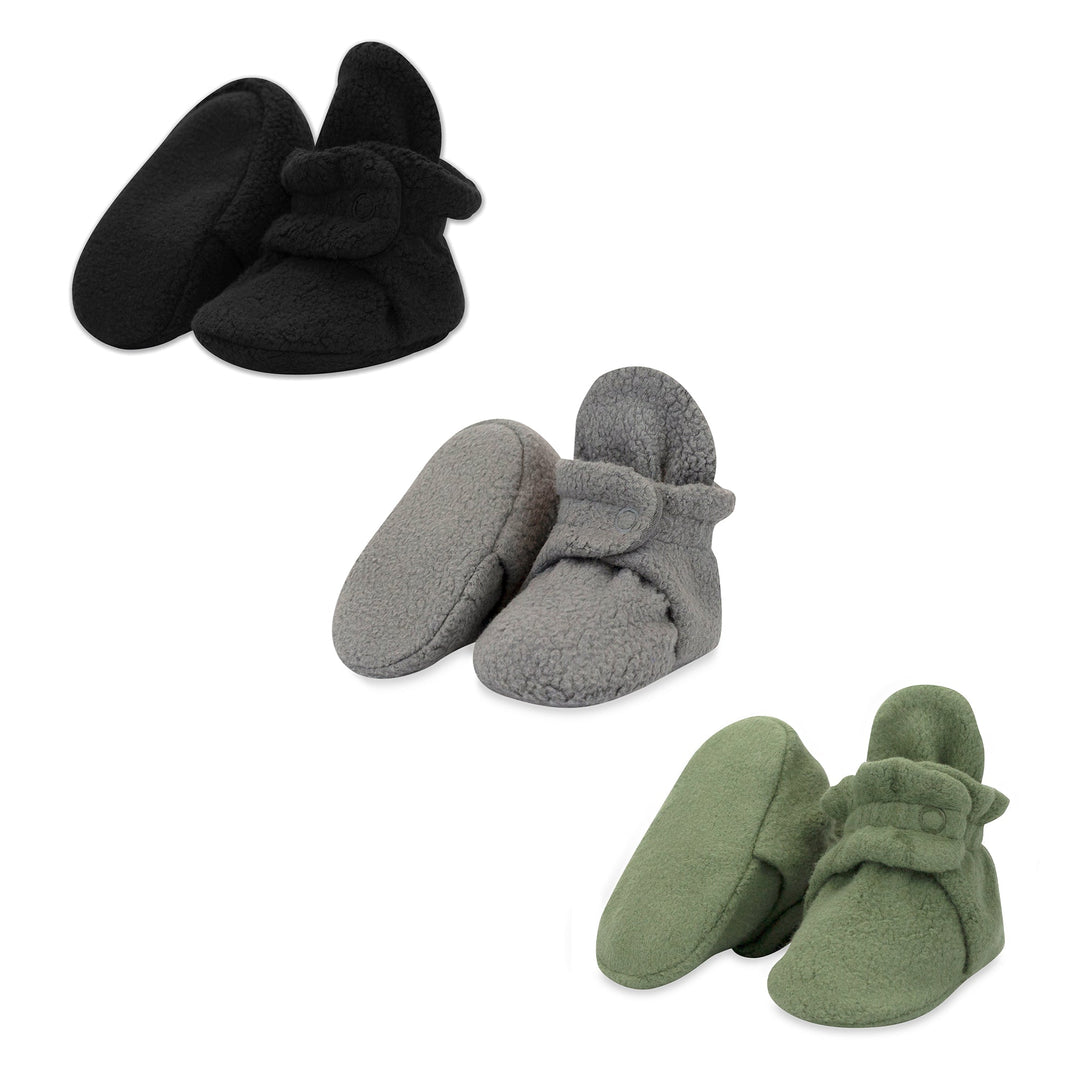 Three pairs of fleece baby booties in black, gray, and olive colors, displayed separately against a white background.