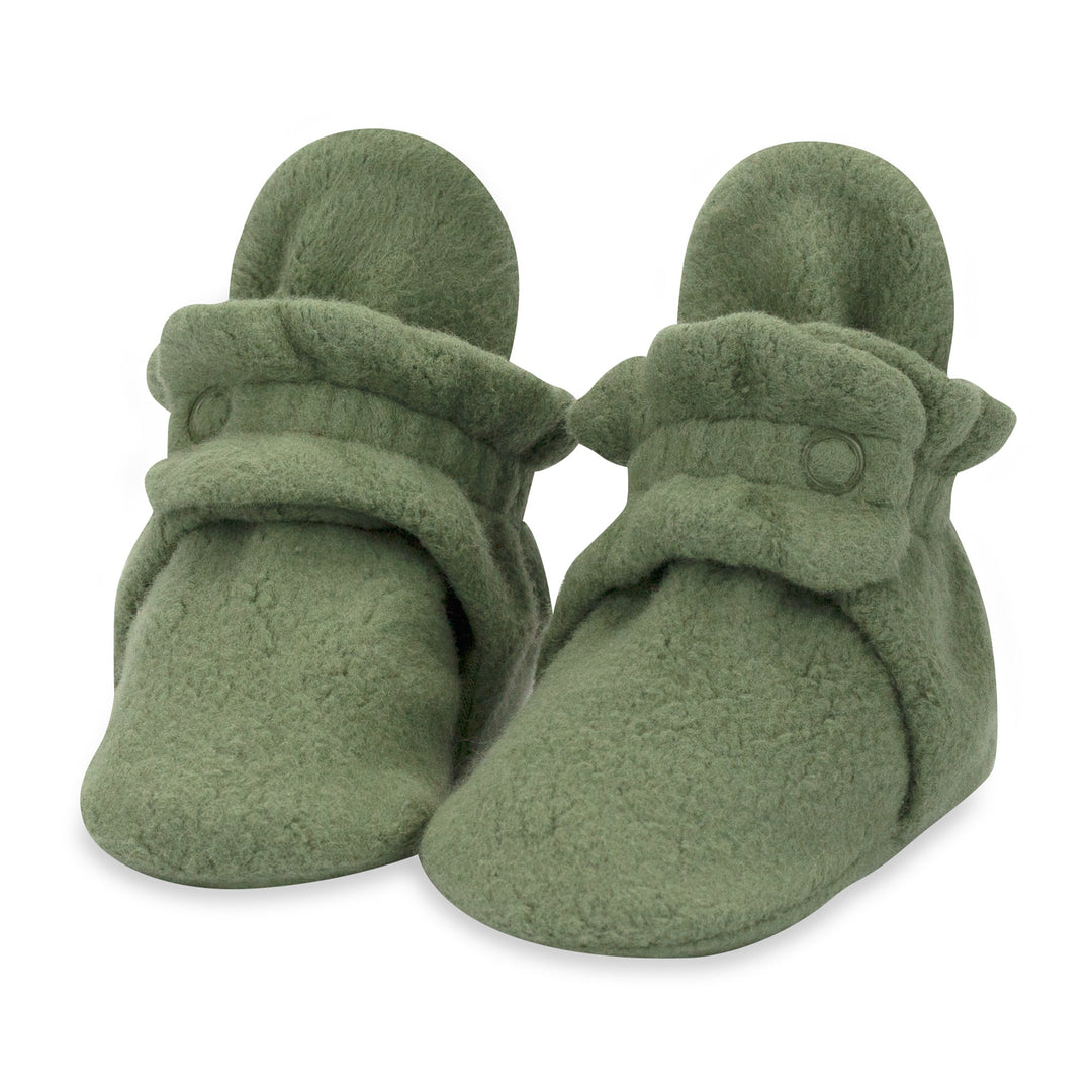 A pair of olive green baby booties with two adjustable snaps on the top.