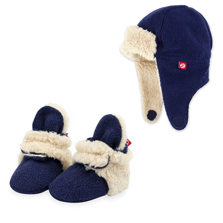 A set of navy blue furry booties and a matching trapper hat for babies
