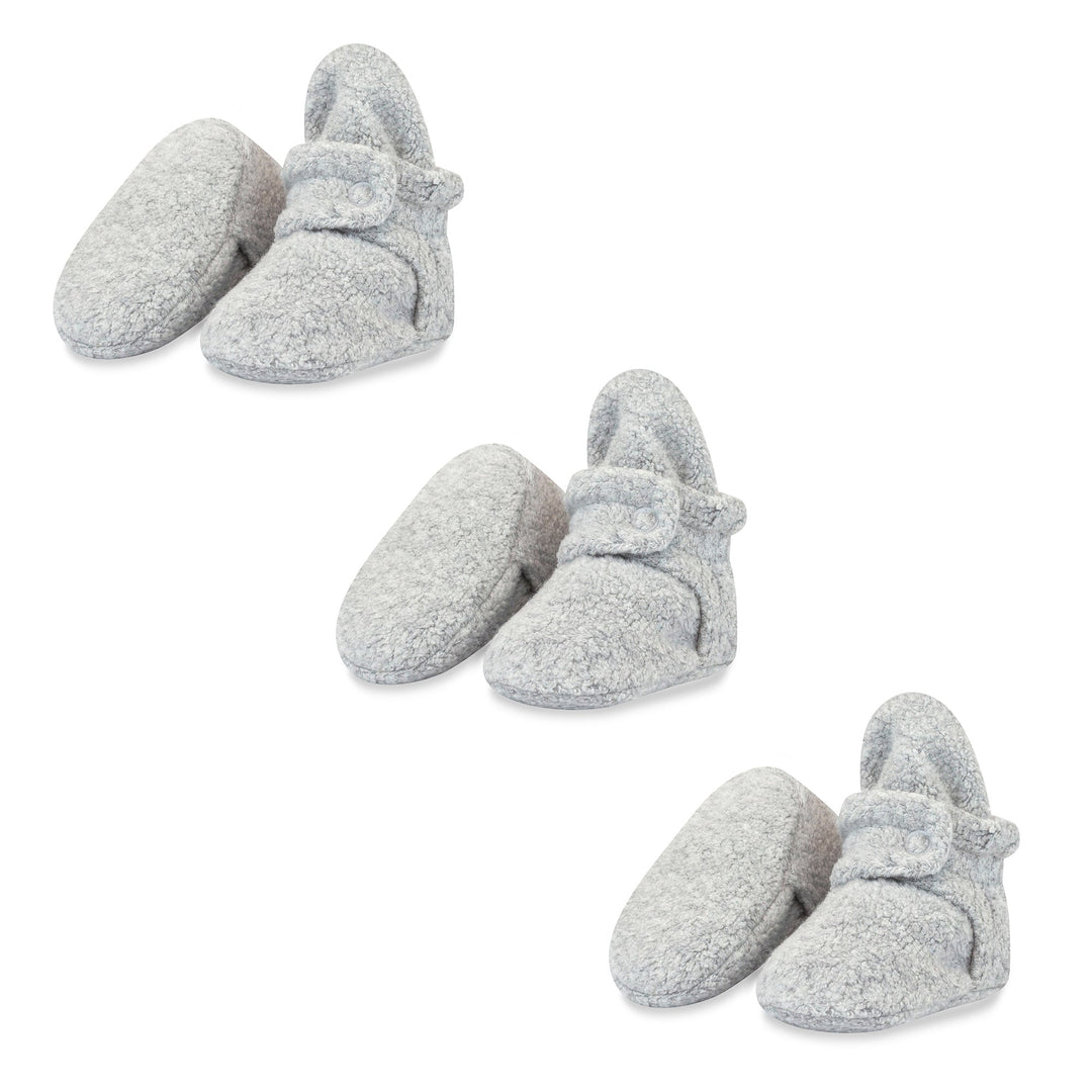 Three pairs of heather gray baby booties with adjustable snaps, made of fleece fabric.