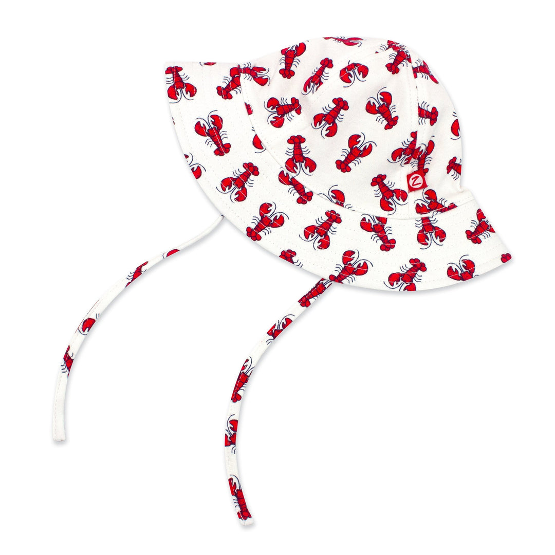 A white organic cotton sun hat with red lobster prints, featuring a wide brim and chin ties.