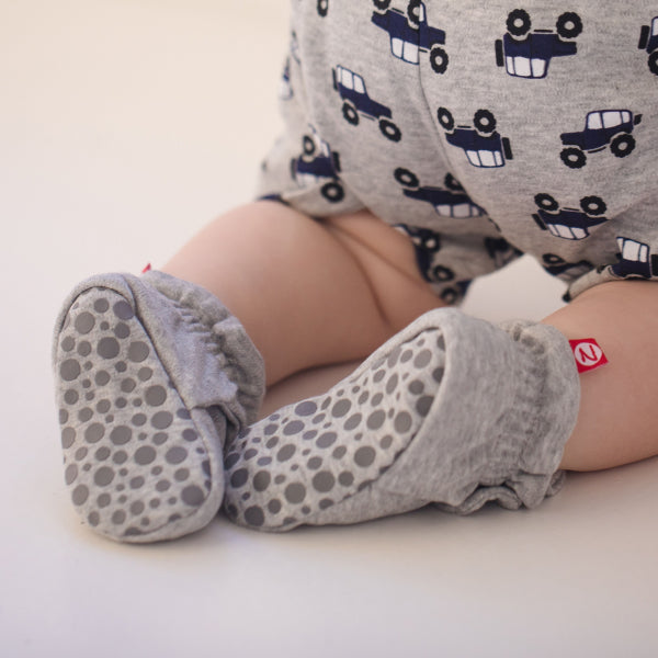 Baby wearing a Zutano organic cotton sun hat and matching booties in a soft outdoor setting