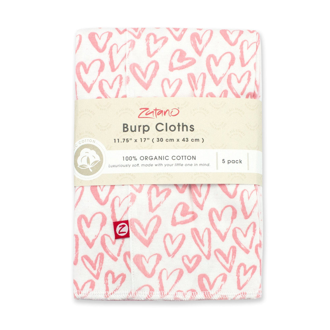 A packaged set of five organic cotton burp cloths with a pink and white heart print.