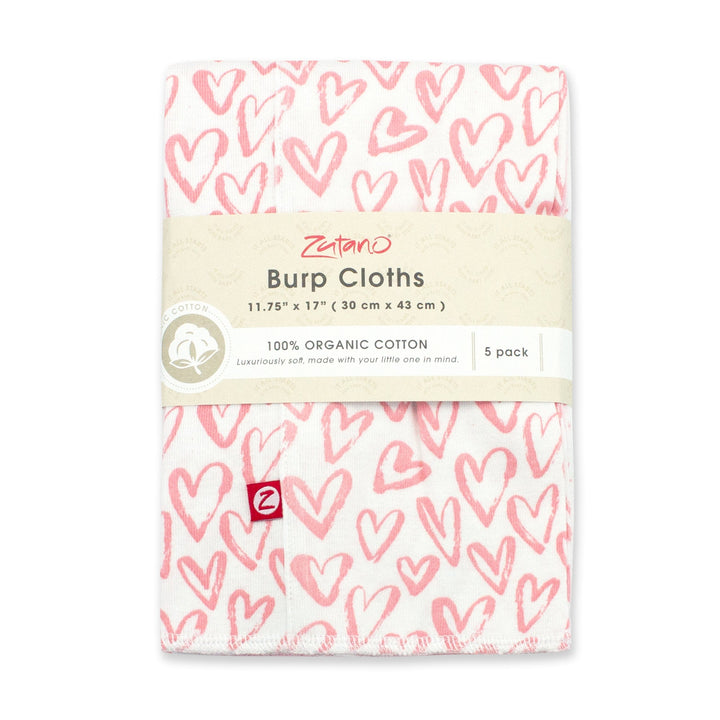 A packaged set of five organic cotton burp cloths with a pink and white heart print.