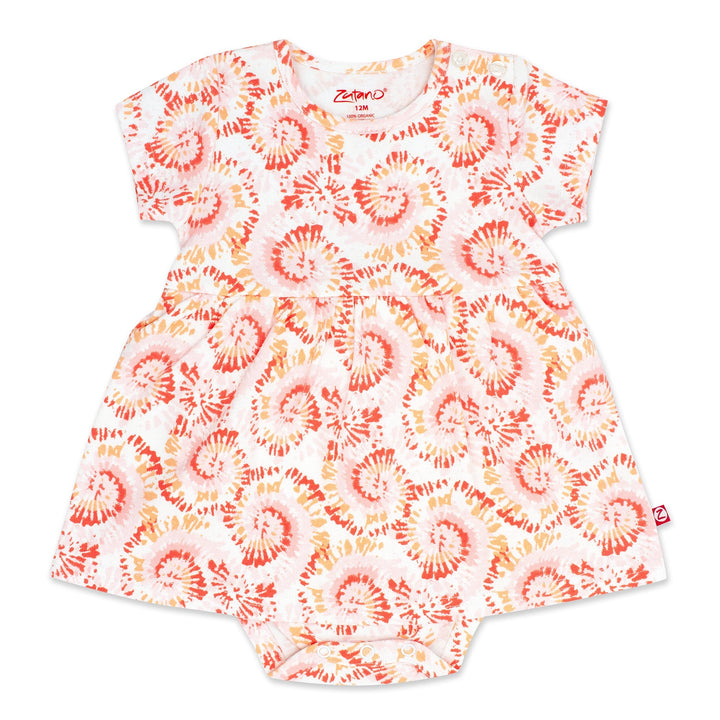 A short-sleeved tie-dye organic cotton romper dress for a baby girl, predominantly in a coral color.