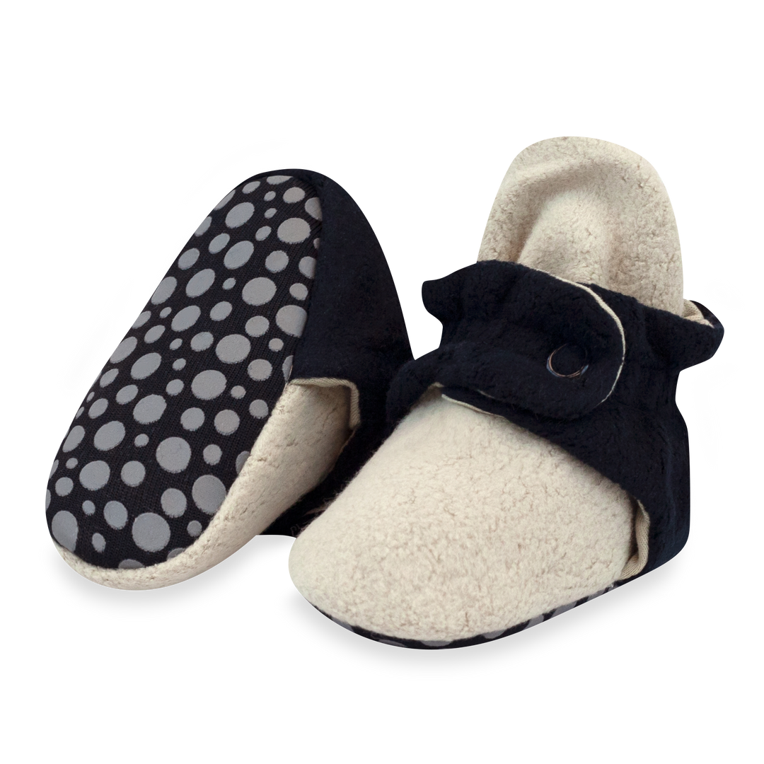 A pair of baby booties in color block design with a fleece exterior and appear to have a soft, plush texture.