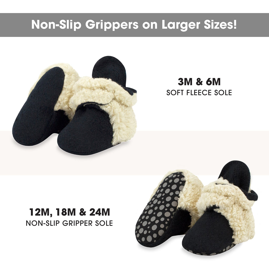 Black baby booties with beige furry detailing on the top and around the sole.