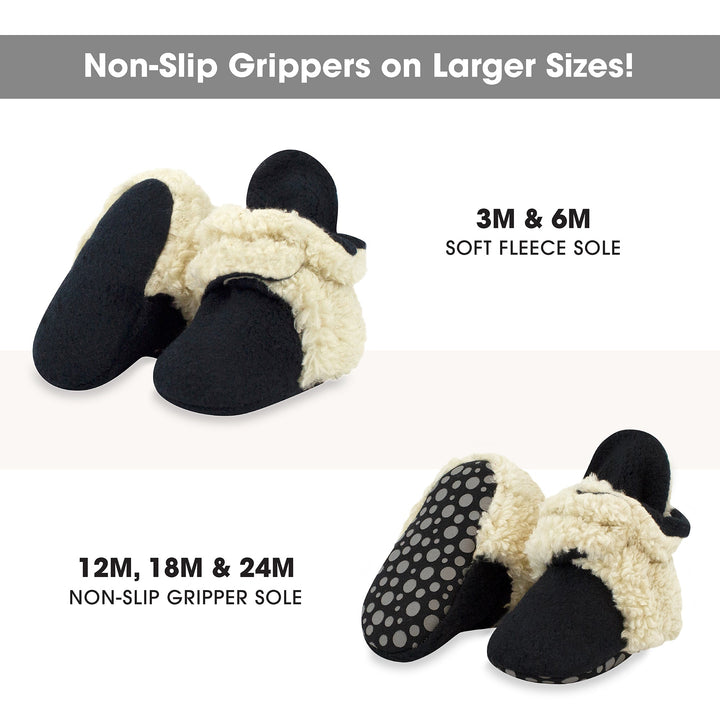 Black baby booties with beige furry detailing on the top and around the sole.