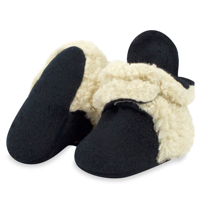 Black baby booties with beige furry detailing on the top.