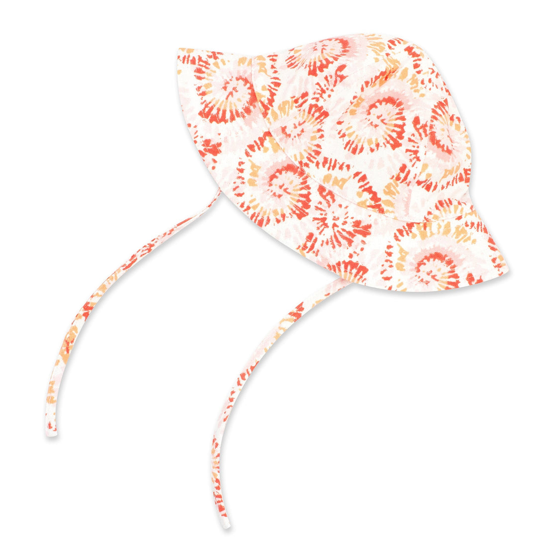 A tie-dye organic cotton sun hat in coral color with a wide brim and chin ties.