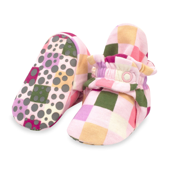 A pair of multicolored checkered baby booties with gripper soles and a snap closure.