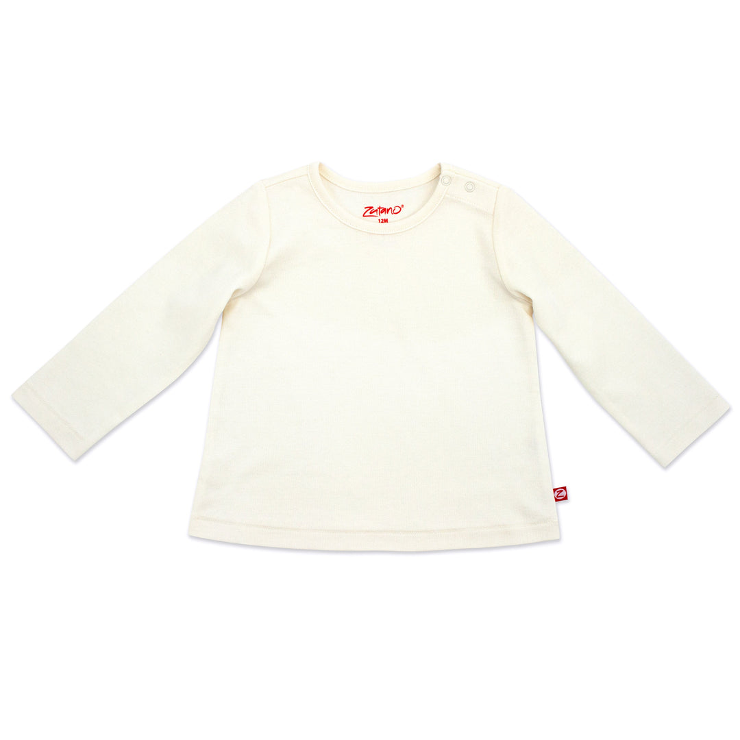 A long sleeve cream-colored baby girl's shirt laid flat on a white background.