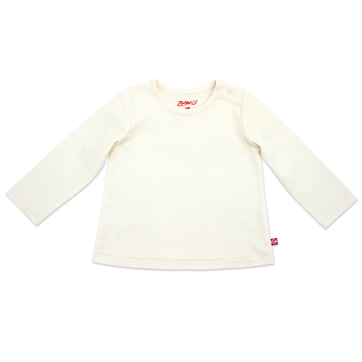 A long sleeve cream-colored baby girl's shirt laid flat on a white background.