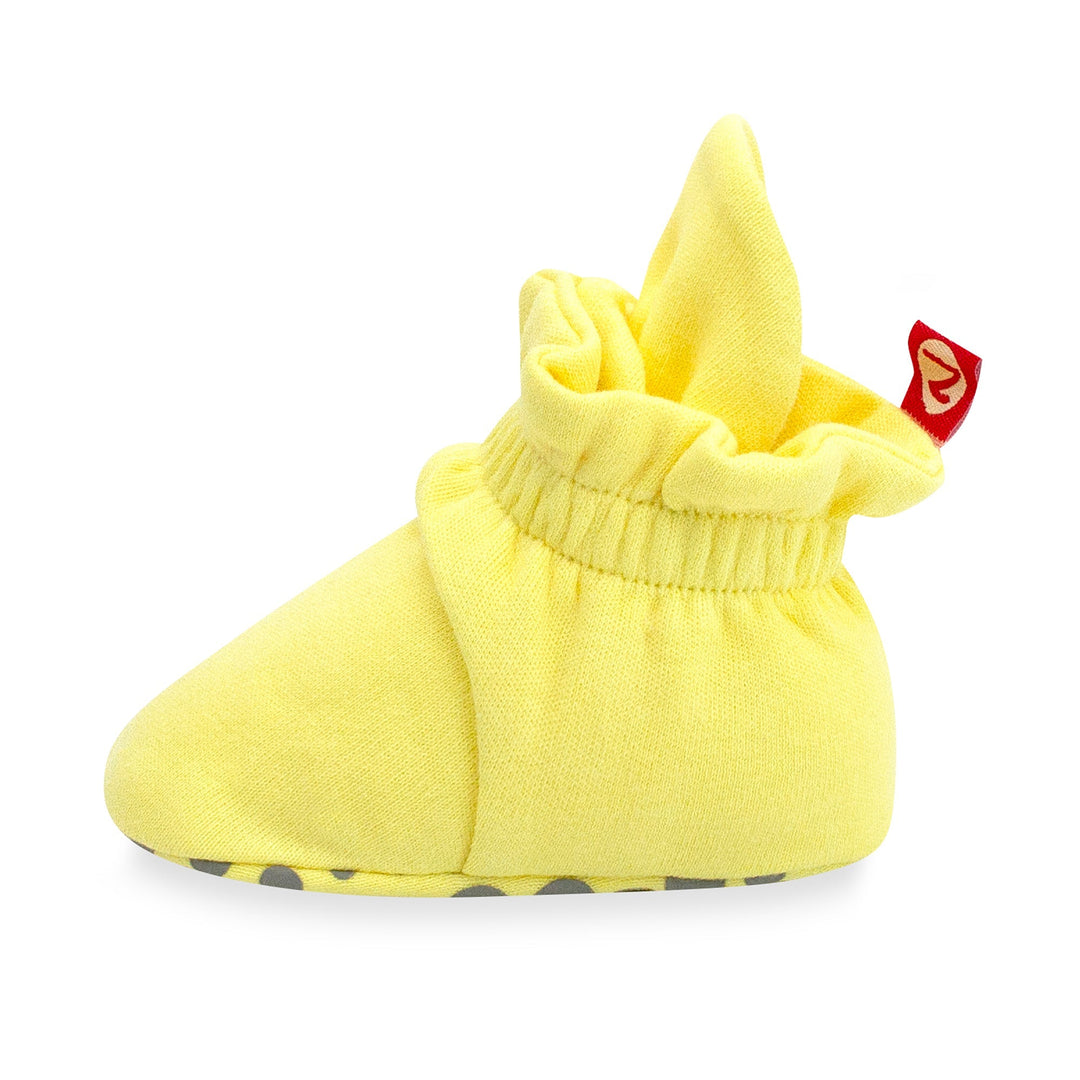 Yellow organic cotton baby booties with gripper soles and a popcorn print.