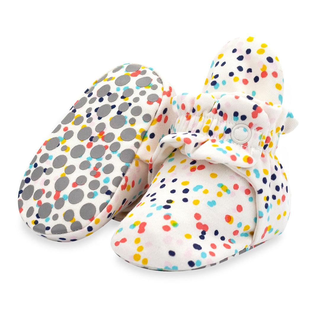 A pair of organic cotton baby booties with a multicolored confetti print.