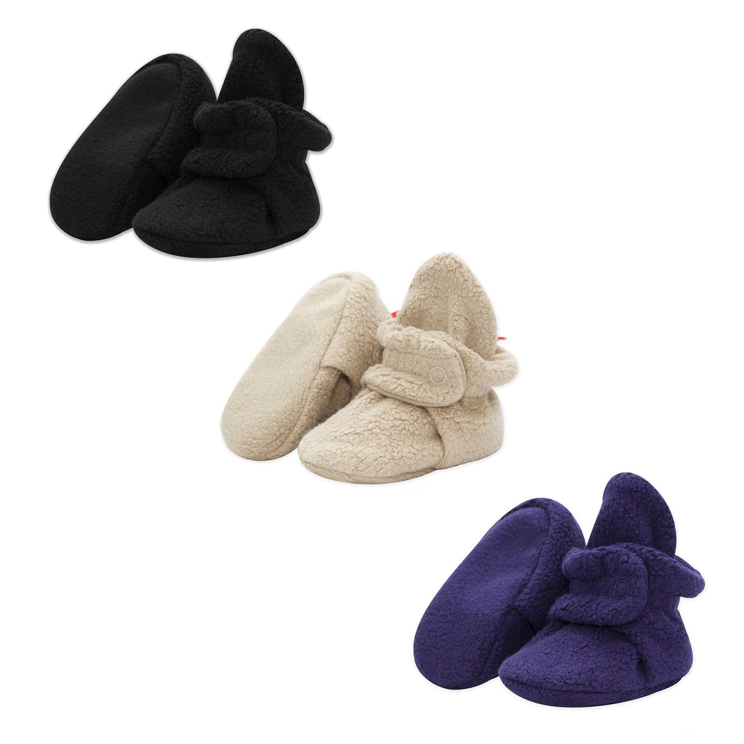 Three pairs of baby booties in black, khaki, and navy colors, made of fleece, displayed against a white background.