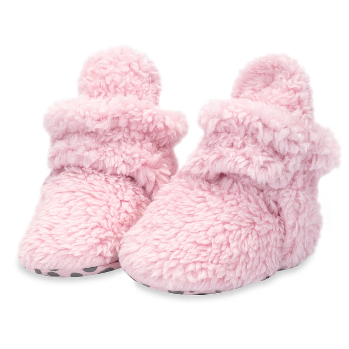 Baby booties with faux fur exterior and gripper soles.