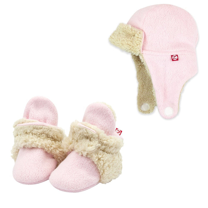 A set of baby pink furry booties and a matching trapper hat with a soft furry lining.