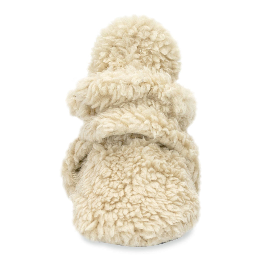 A set of beige baby booties with faux fur exterior and gripper dots on the sole.