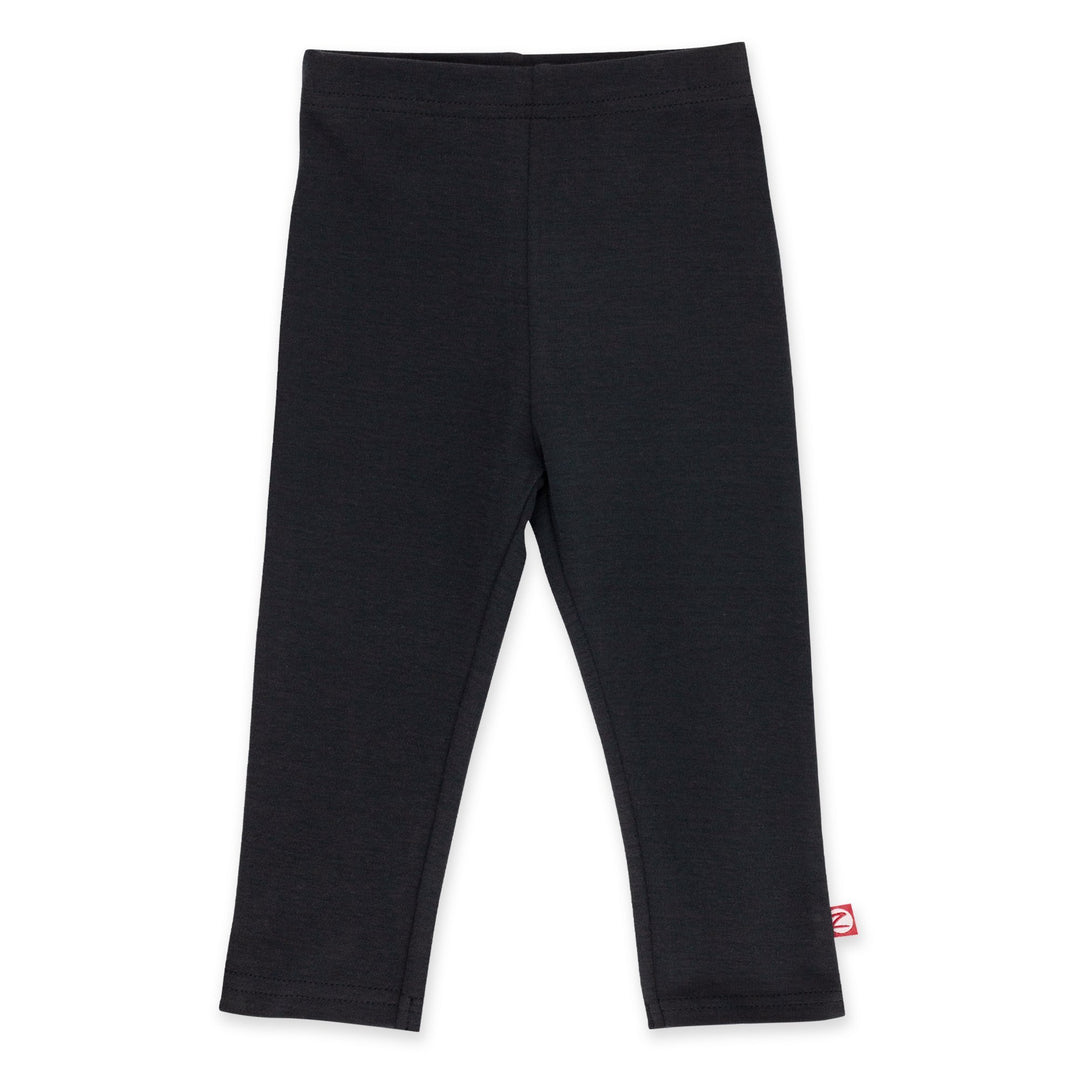 A pair of black organic cotton leggings for kids, with a small red label visible on the bottom right leg.