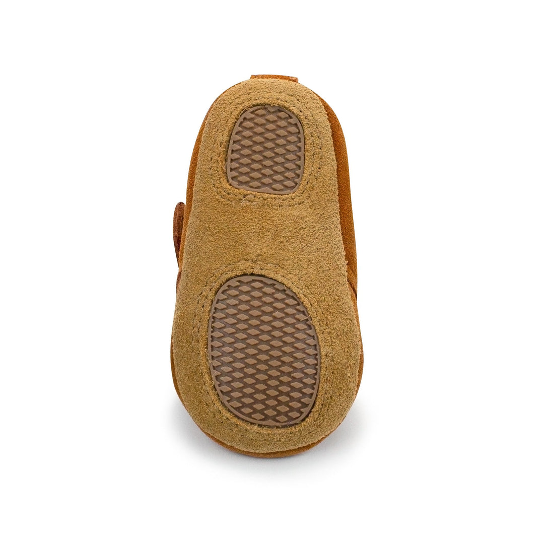 A pair of brown baby shoes with furry lining and a Velcro strap across the front.