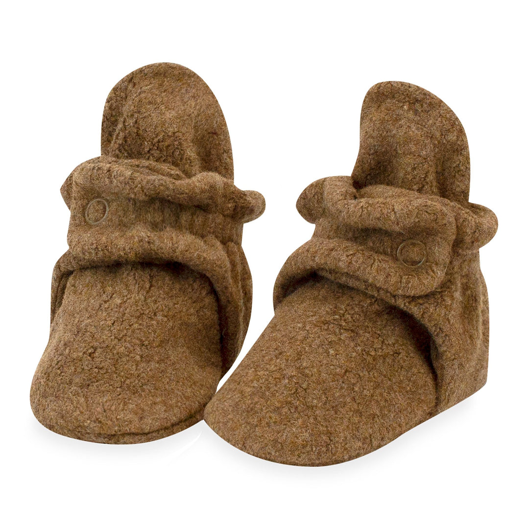 A pair of brown fleece baby booties with two adjustable snaps.