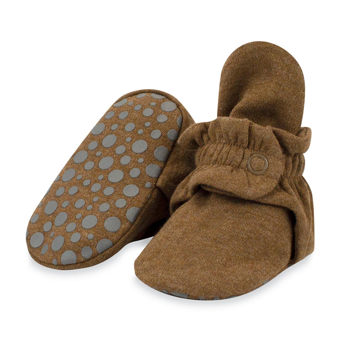 A pair of brown organic cotton baby booties with rubber grippers on the bottom, displayed against a white background.