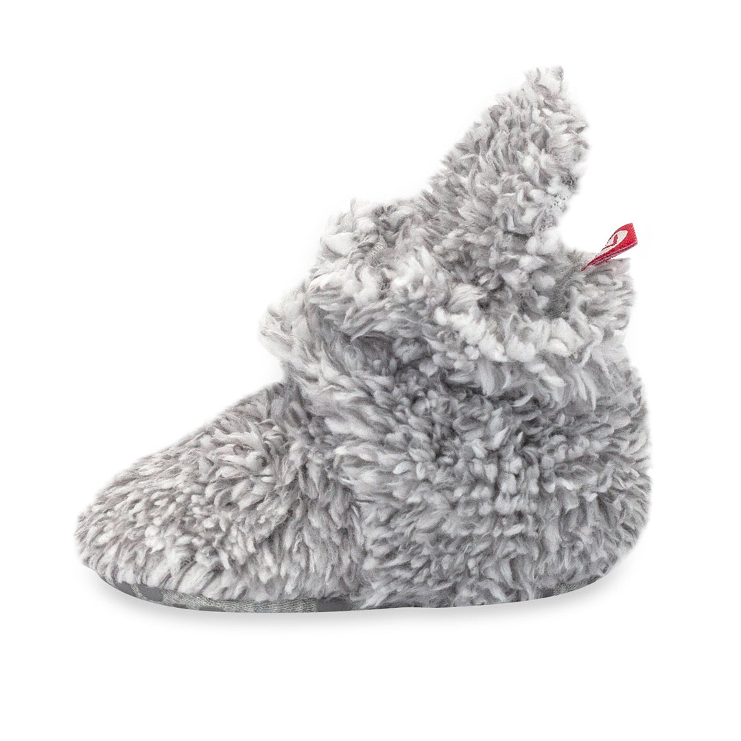 Faux fur baby booties with gripper dots on the bottom.