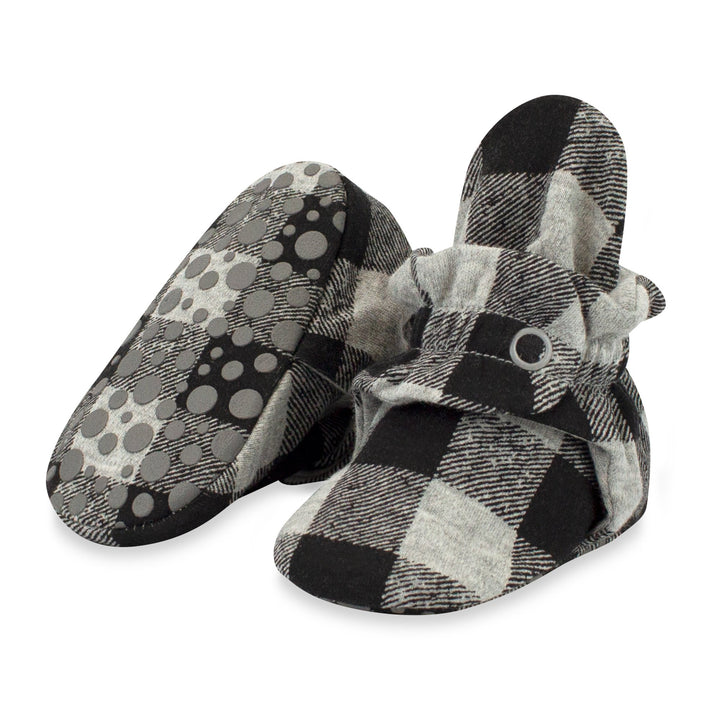 A pair of gray buffalo check organic cotton baby booties with gripper soles and a two-snap secure fit.