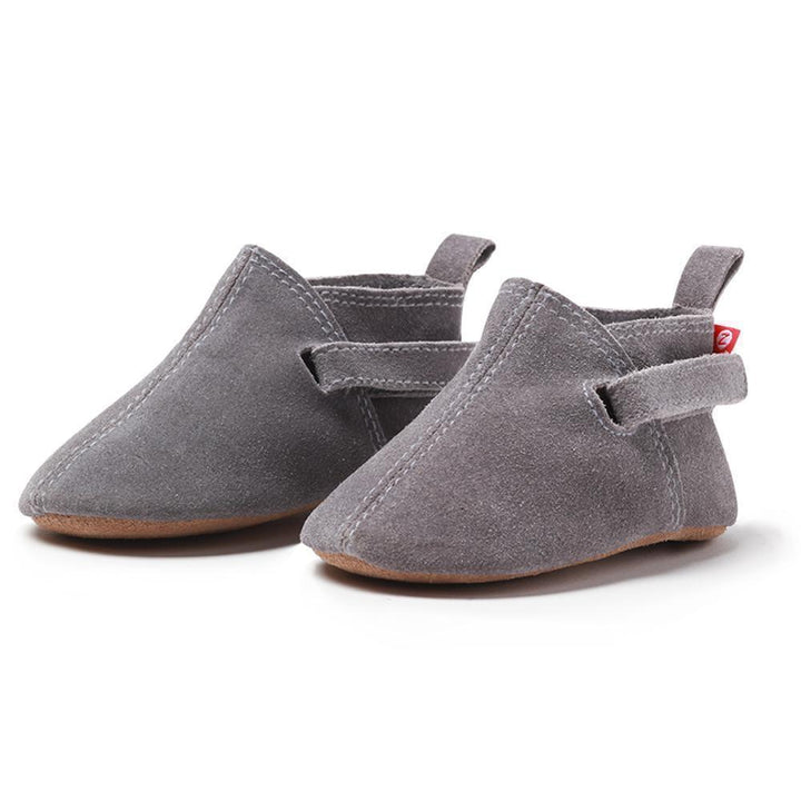 A pair of gray suede baby shoes with adjustable hook and loop straps.