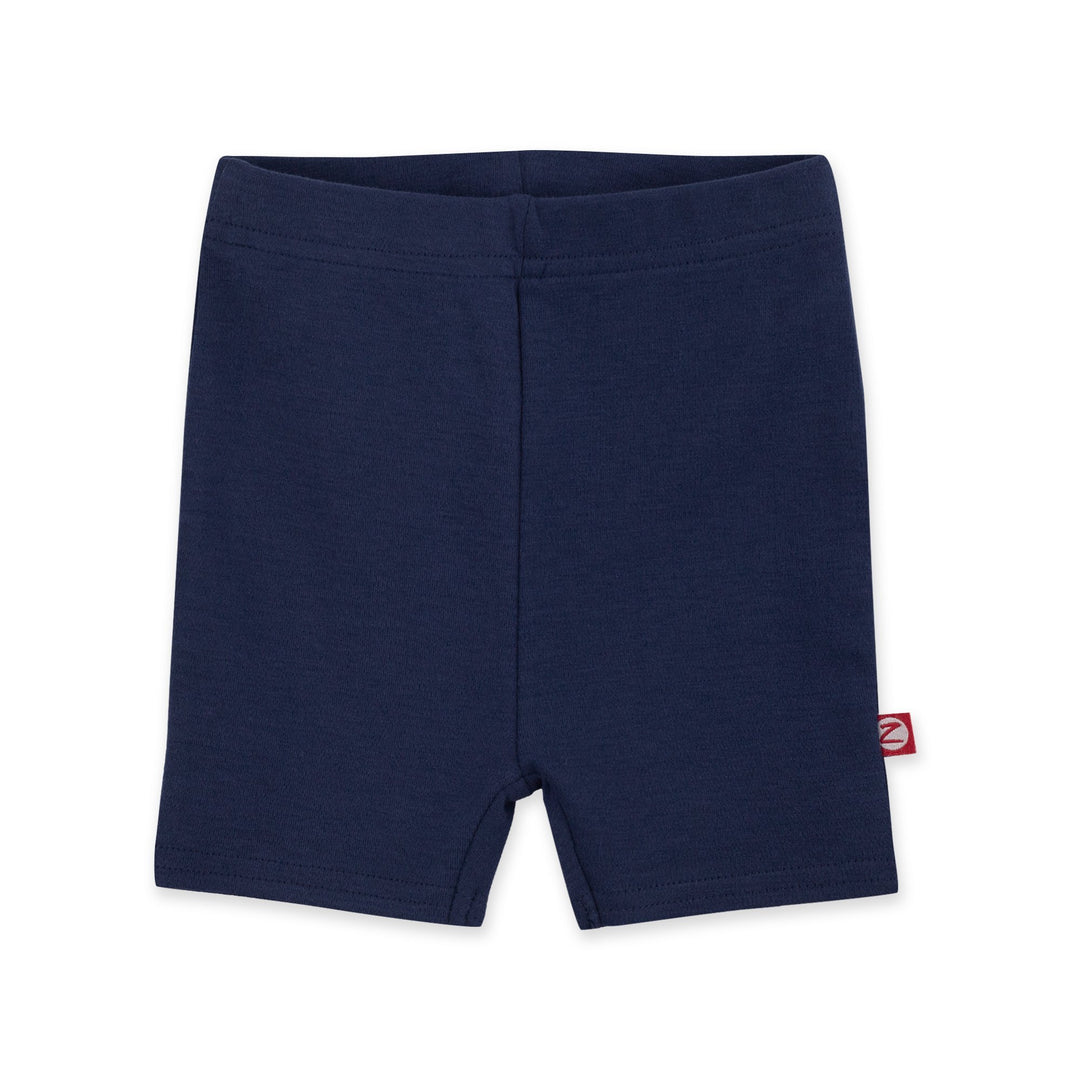A pair of navy blue organic cotton bike shorts for babies, with a visible brand tag on the bottom right shorts.