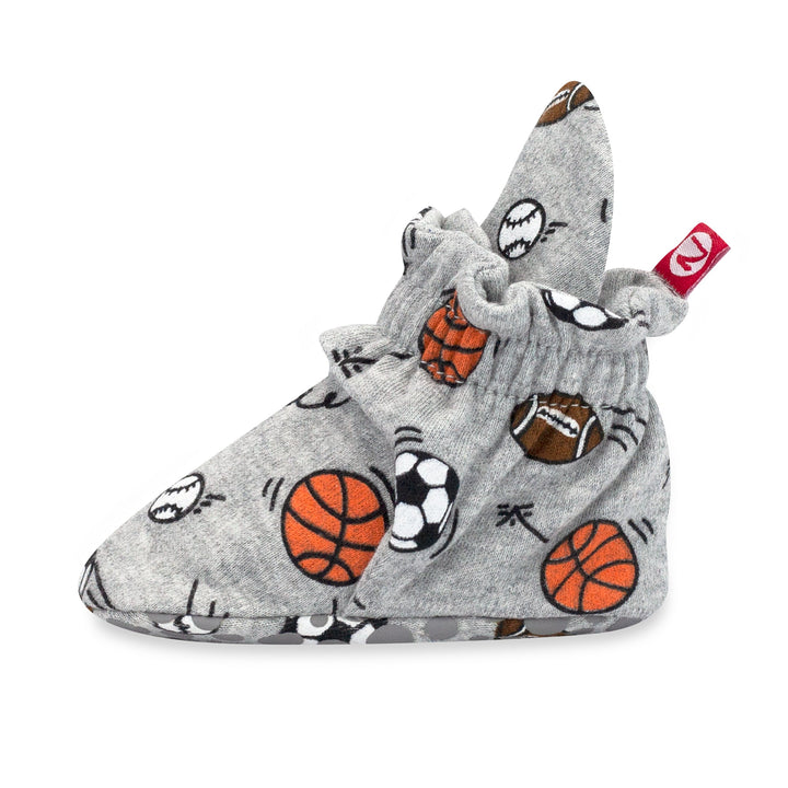 Set of gray and orange organic cotton gripper baby booties with sports prints, including basketballs and soccer, and with rubber grippers on the bottom.