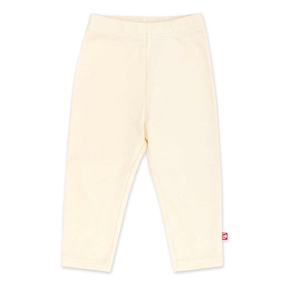 A pair of cream-colored organic cotton leggings for babies, with a thick elastic waist band.