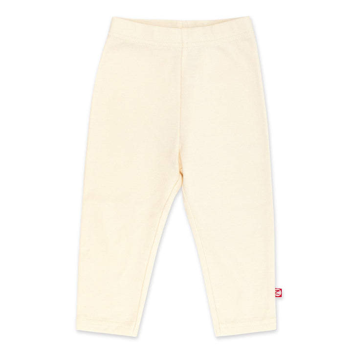 A pair of cream-colored organic cotton leggings for babies, with a thick elastic waist band.