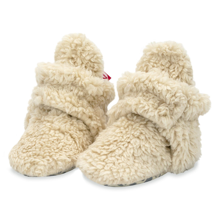 Set of beige furry booties and a matching hat made from organic cotton. 