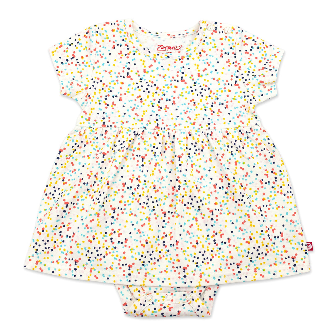 A short-sleeved romper dress for a baby girl with a multicolored confetti print, made from organic cotton, with snaps at the shoulder and between the legs.