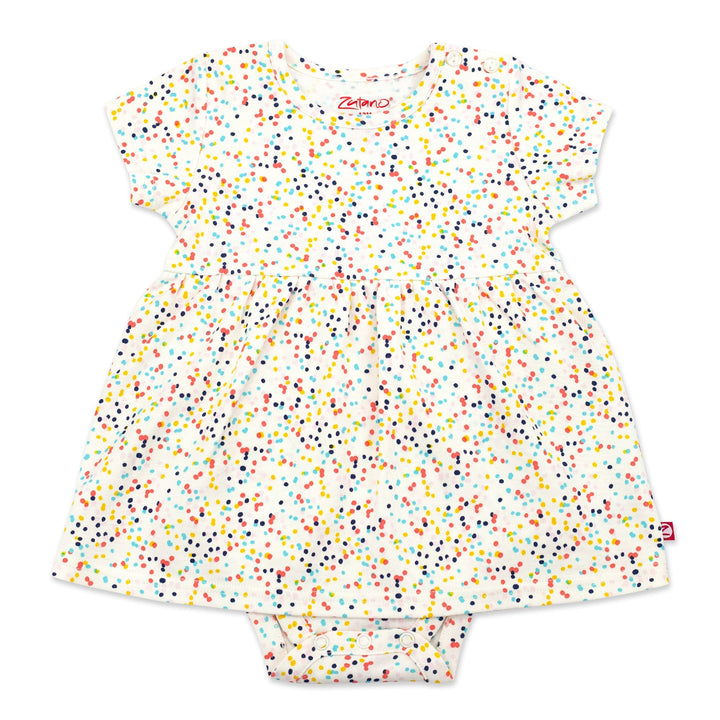 A short-sleeved romper dress for a baby girl with a multicolored confetti print, made from organic cotton, with snaps at the shoulder and between the legs.
