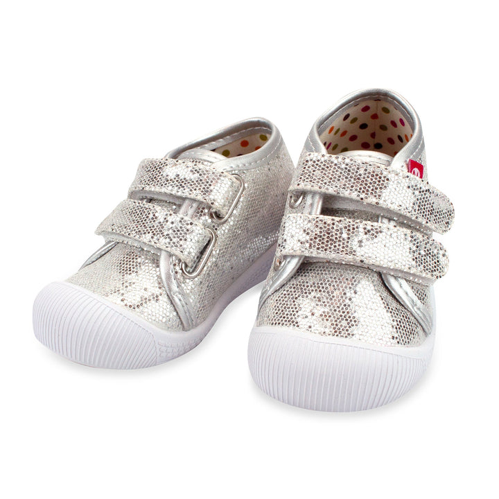 A pair of silver sparkle baby shoes with double velcro straps and a white sole.
