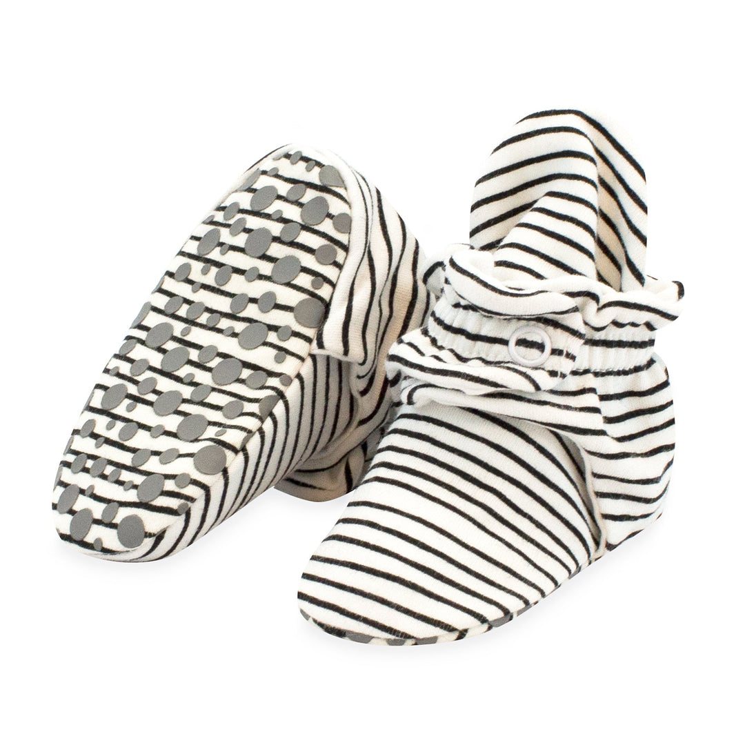 A pair of black and white striped organic cotton baby booties with gripper soles.