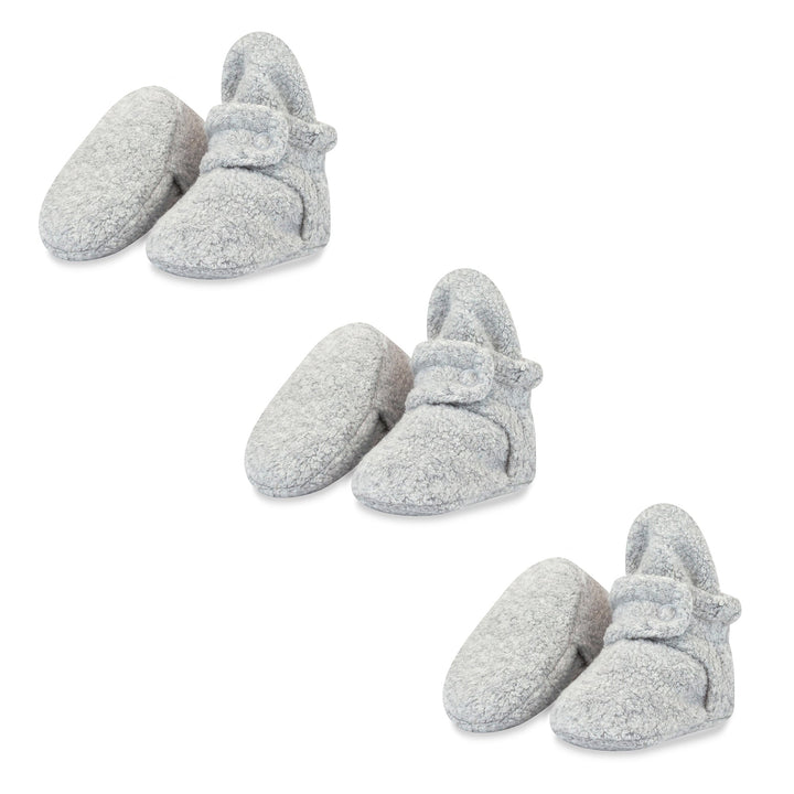 Three pairs of heather gray baby booties with adjustable snaps, made of fleece fabric.