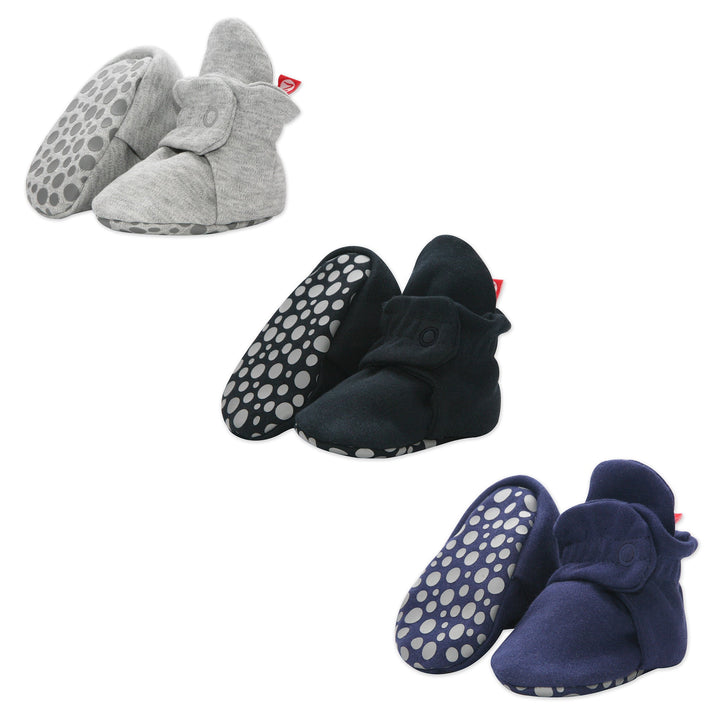 Three pairs of organic cotton gripper baby booties in Heather Gray, Black, and True Navy colors, displayed against a white background.