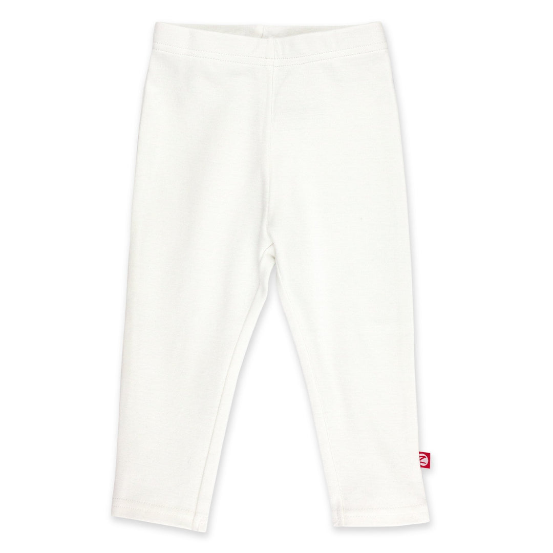 A pair of white organic cotton leggings for babies, with a visible red label on the lower right leg.