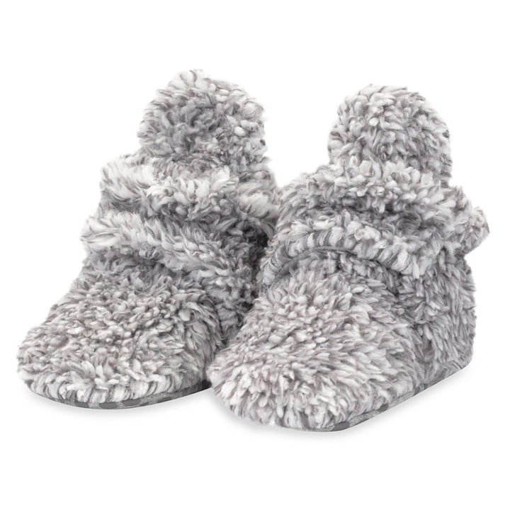 Faux fur baby booties with gripper dots on the bottom made from organic cotton.